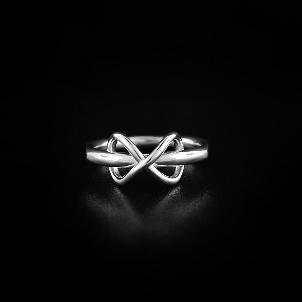 This sterling silver wire ring has a thin, wire band with wires forming an infinity sign at the top of the band.