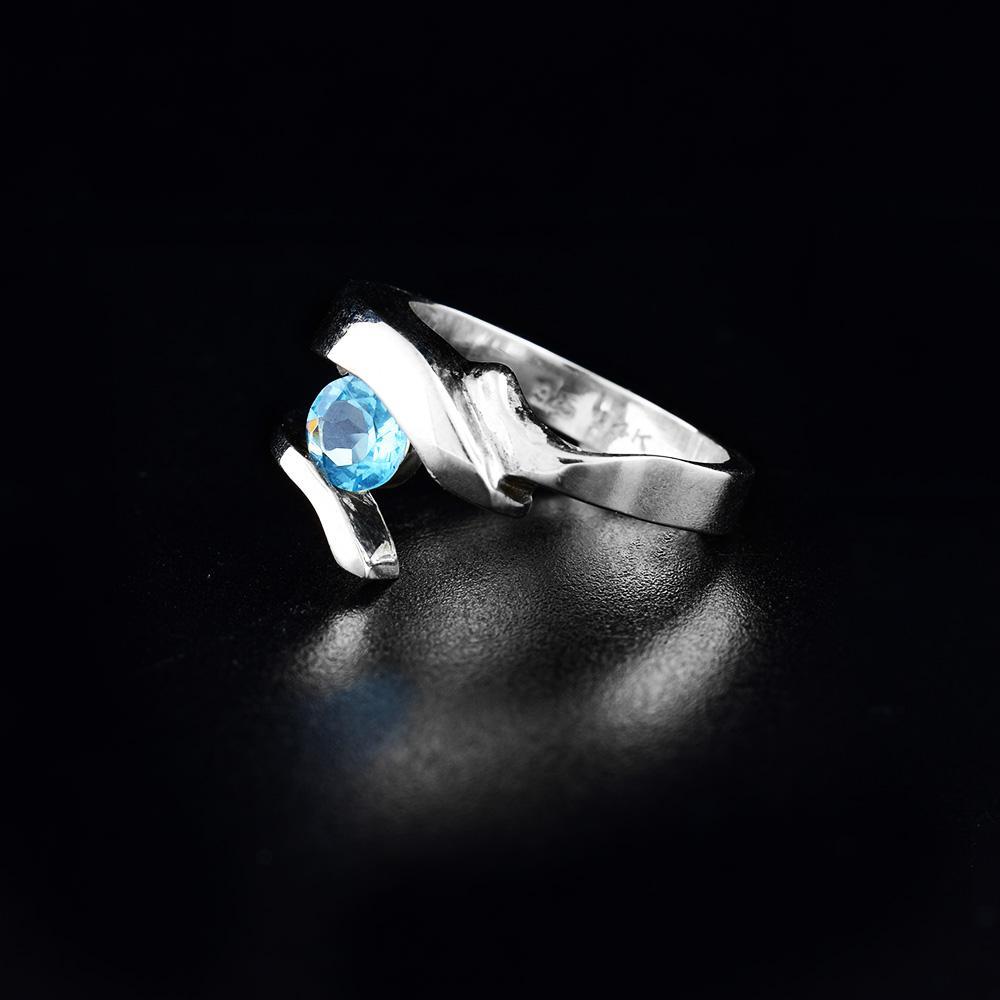 This blue topaz silver ring has a sterling silver band that splits in two at the top of the ring. Between the split, there is a gorgeous blue topaz gemstone.