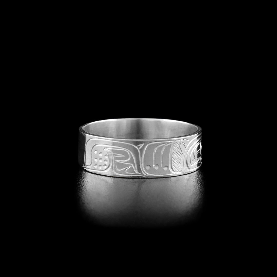 Left angle photo of the ring shows carved designs representing the bear's body and large paw.