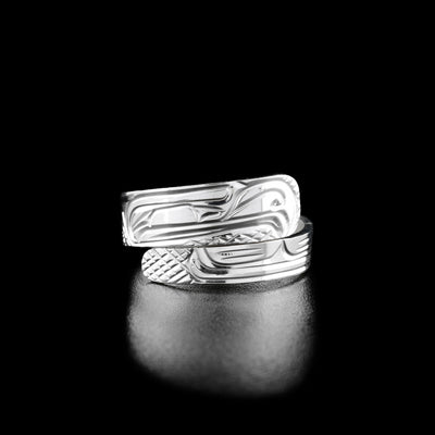 Sterling Silver 1/4' Tapered Thunderbird Wrap Ring by Victoria Harper. The top part of this wrap ring depicts the profile of a thunderbird's head facing towards the right. The thunderbird has a long, pointy beak and a feather on the back of its head. The bottom part of this wrap ring the artist has hand-carved the feather of the thunderbird.
