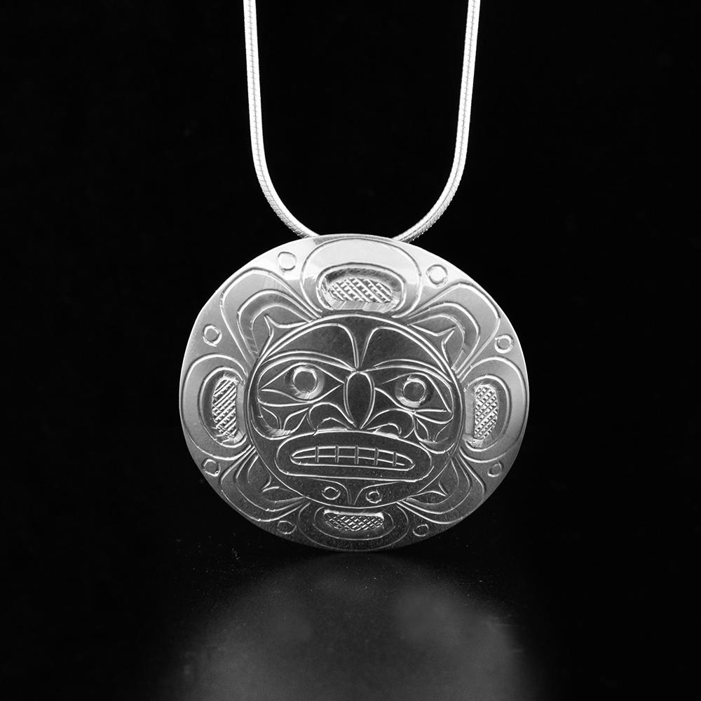 This sterling silver Moon pendant is circle shaped and has beautiful carvings on the surface of it depicting the Moon.
