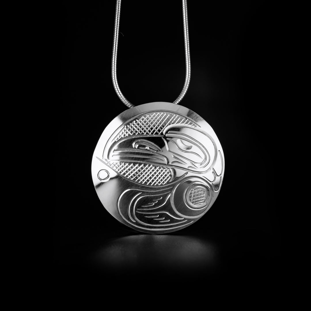 This Round Raven Pendant is handmade by Kwakwaka'wakw artist, John Lancaster, from sterling silver. The pendant measures 1.26" in diameter.  The Raven Legend Represents: CREATIVITY, MISCHIEF, MAGIC.