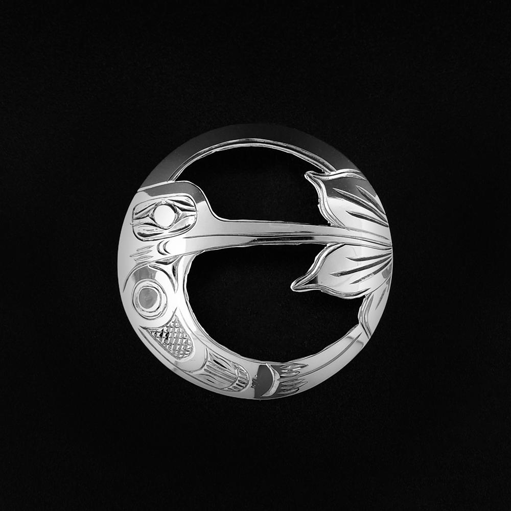This Hummingbird pin (brooch) is made from sterling silver and has a stainless steel pin in the back. The brooch is circle shaped with carving that depict the Hummingbird and a flower on the surface of it. The pendant is cutout around the design of the Hummingbird and the flower.