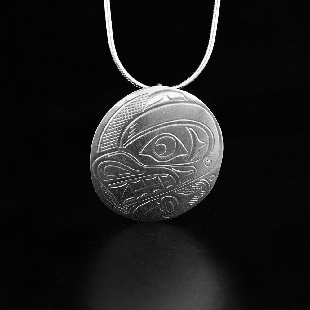 This sterling silver pendant is large and circle shaped. There is a depiction of the Bear carved into the surface of the pendant.
