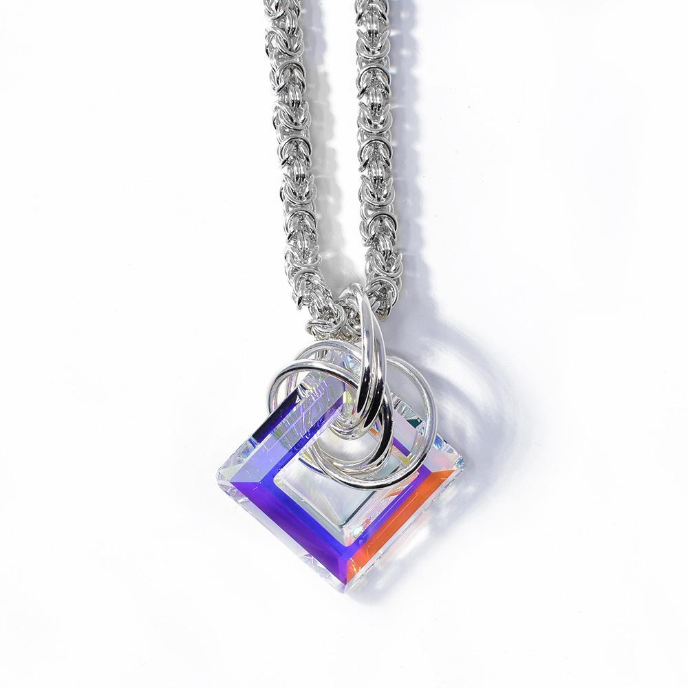 This aurora borealis Swarovski crystal pendant has a square crystal with a cutout in the middle of it. There are many sterling silver hoops linked through the crystal on the chain.