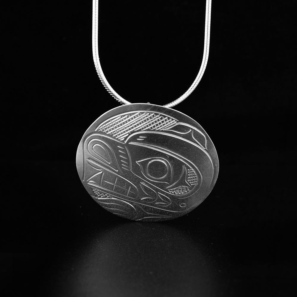 This Bear pendant is made from sterling silver and is circle shaped. There is a depiction of the Bear carved into the surface of the pendant.