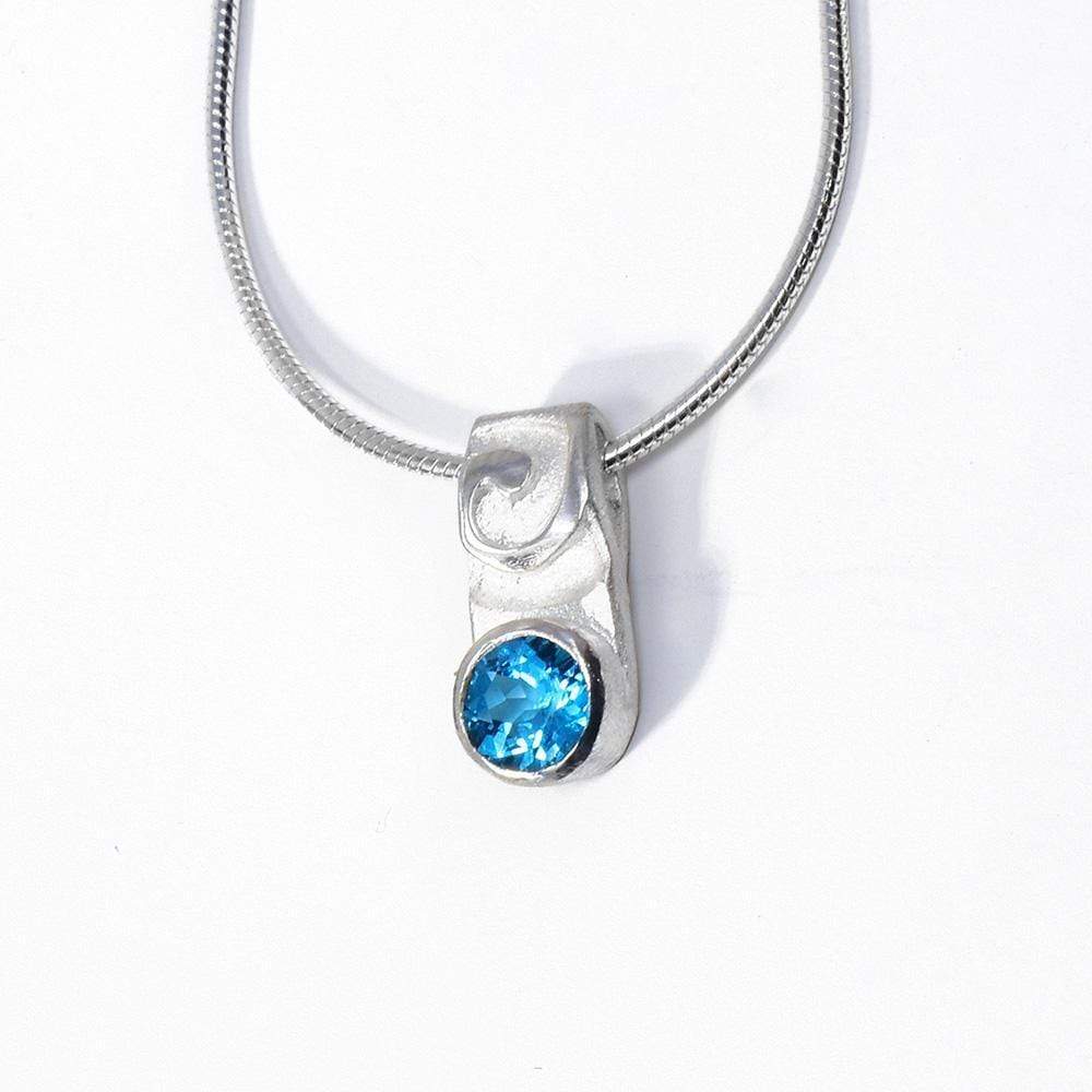 This blue topaz necklace has an oval shaped, sterling silver pendant with swirling designs on the surface of it. The topaz gemstone is set in the bottom half of the pendant.