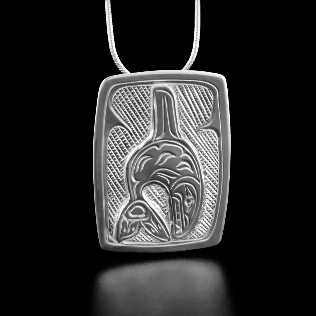 Sterling Silver Rectangular Orca Pendant by Victoria Harper. The artist has hand-carved an orca as if mid-leap in the center of the pendant. The background has been neatly hand-carved in a crisscross pattern to allow for the orca to stand out.