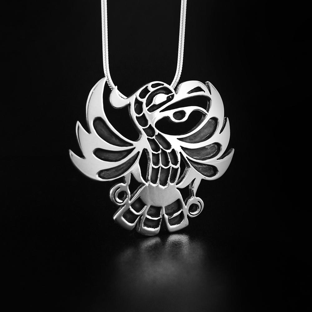 This Eagle pendant is in the shape of an Eagle looking to the right with an open beak and its wings spread out. The layer underneath has been oxidized to create contrast against the top layer of sterling silver.