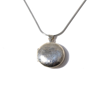 This Large Silver Hammered Locket is handmade by artist Pamela Lauz.   The locket has a hammered finish, giving it its unique texture on top. The bottom of the locket has a polished finish.   The locket measures 1.28" x 1.0", including the bail.  The chain is not included.