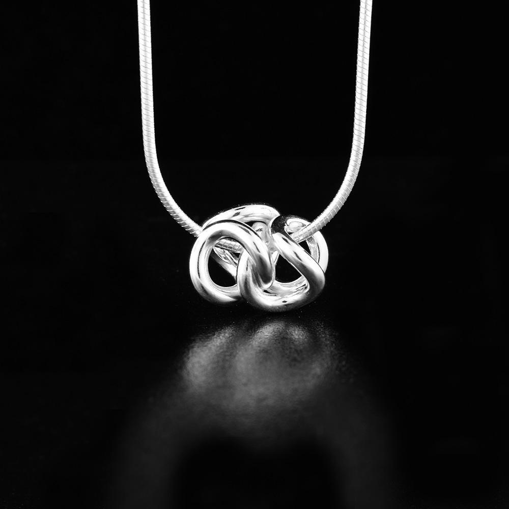 This love knot pendant is made from sterling silver and consists of two, curved knots interlocked with each other.