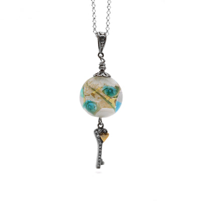 This Sterling Silver Southseas Necklace is handcrafted by artist Wendy Pierson (Island Rain Studio). She has used her signature lampworked glass for the bead pendant and sterling silver for both the chain and the adornments. The necklace is 29.5" long.