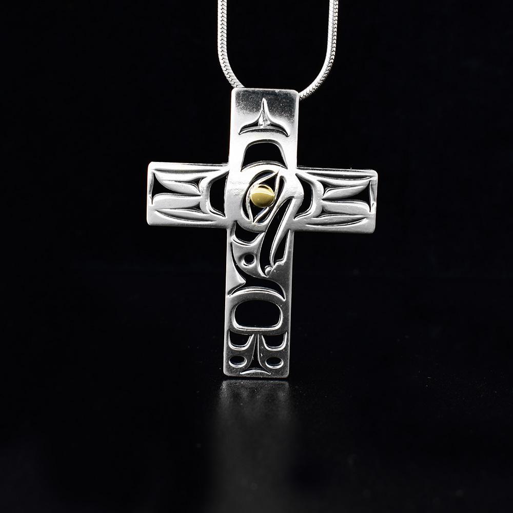 This 18K gold and silver cross pendant is large and cross shaped. There are many, intricate cutout designs on the pendant that depict the Eagle.