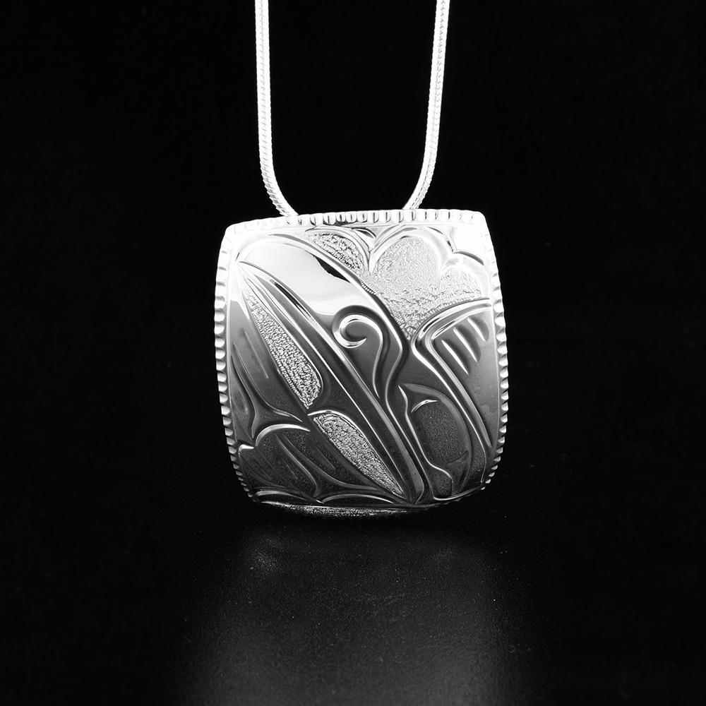 This Raven square pendant has the profile of a raven's head facing upright with its wing underneath.