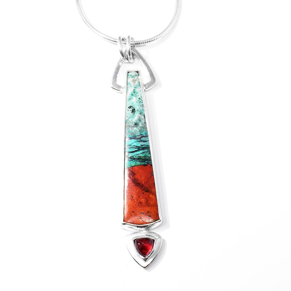 This multiple gemstone pendant is made from chrysocolla, cuprite, garnet and sterling silver. The pendant is long, thin and has a garnet gem hanging from the end. The other gems are set into the rectangle part of the pendant.
