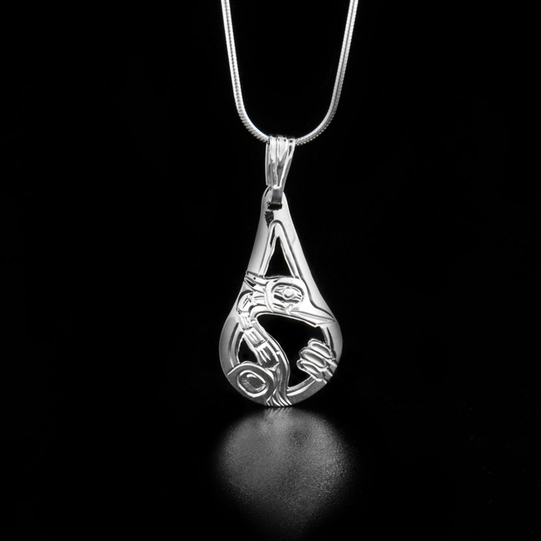 This heron pendant has the profile of a heron's head and long neck facing the right in the center of the pendant with nearby cattails.