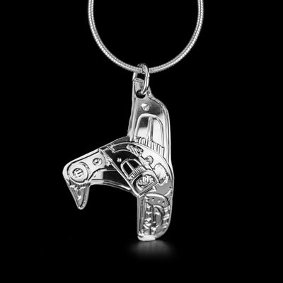 Sterling Silver Orca Shaped Pendant by Jeffrey Pat. The pendant is in the shape of an orca as if it was diving back into the water. The artist has hand-carved intricate details along the body of the orca to represent its unique black and white spots. The bail has been attached to the dorsal fin of the orca.
