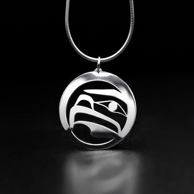 This Sterling Silver Round Eagle Pendant was handmade by Tahltan artist, Grant Pauls. The pendant, made from sterling silver, depicts the side view of an eagle.  The pendant is 1" in diameter.  The chain is not included. The Eagle Legend Represents: VISION, INTELLIGENCE, POWER.