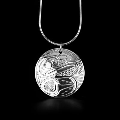 This Round Raven Pendant is handmade by Kwakwaka'wakw artist, Victoria Harper. She has used sterling silver to create this piece. The pendant measures 1.0" in diameter. There is a hidden bail in the back. The chain is not included. The Raven Legend Represents: CREATIVITY, MISCHIEF, MAGIC.