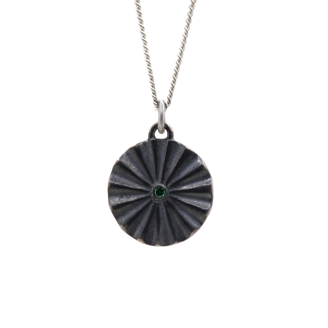 Oxidized necklace hanging from its chain.