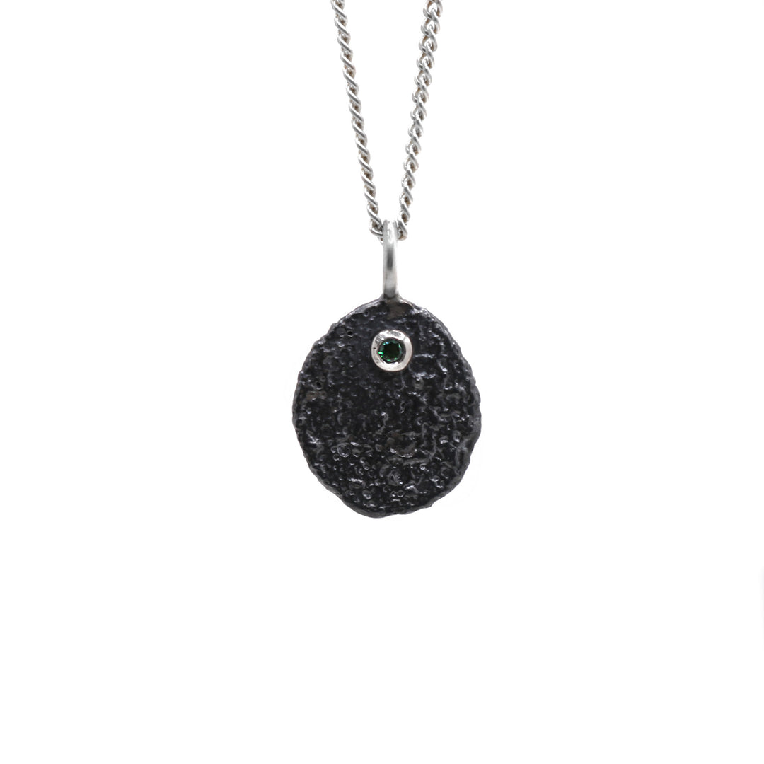 Oxidized necklace hanging from its chain.