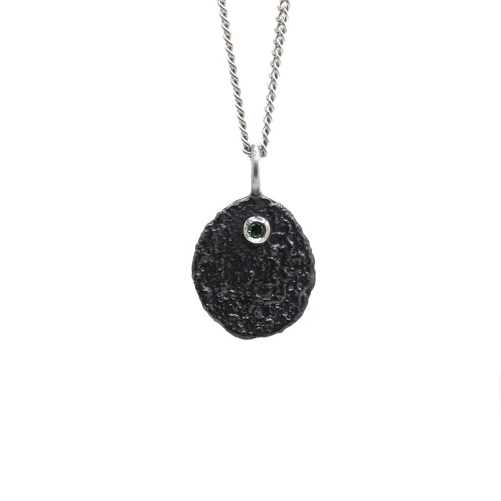 Oxidized necklace hanging from its chain.