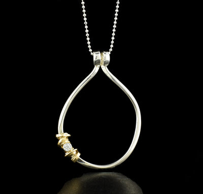 Sterling Silver Circular Coiled Necklace handcrafted by artist Joy Annett using sterling silver, cubic zirconia, and 14k gold-filled accents.