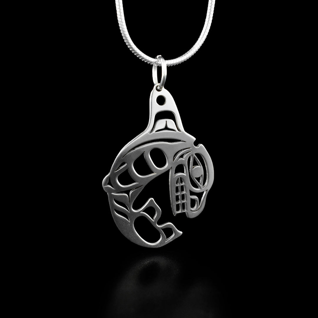 This orca pendant depicts an orca at the peak of its jump out of the water. Parts of the orca have been cut out to create depth.