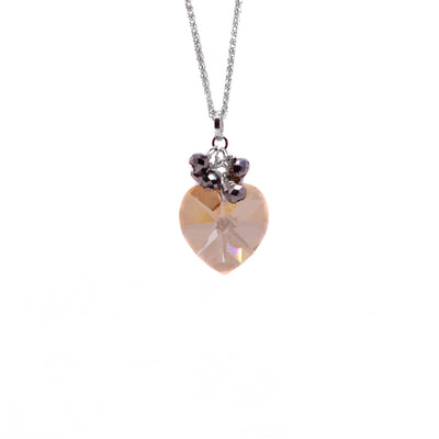 This crystal heart pendant is heart-shaped and peach coloured. There are 6 round, small metallic rondelles attached to the silver bail.