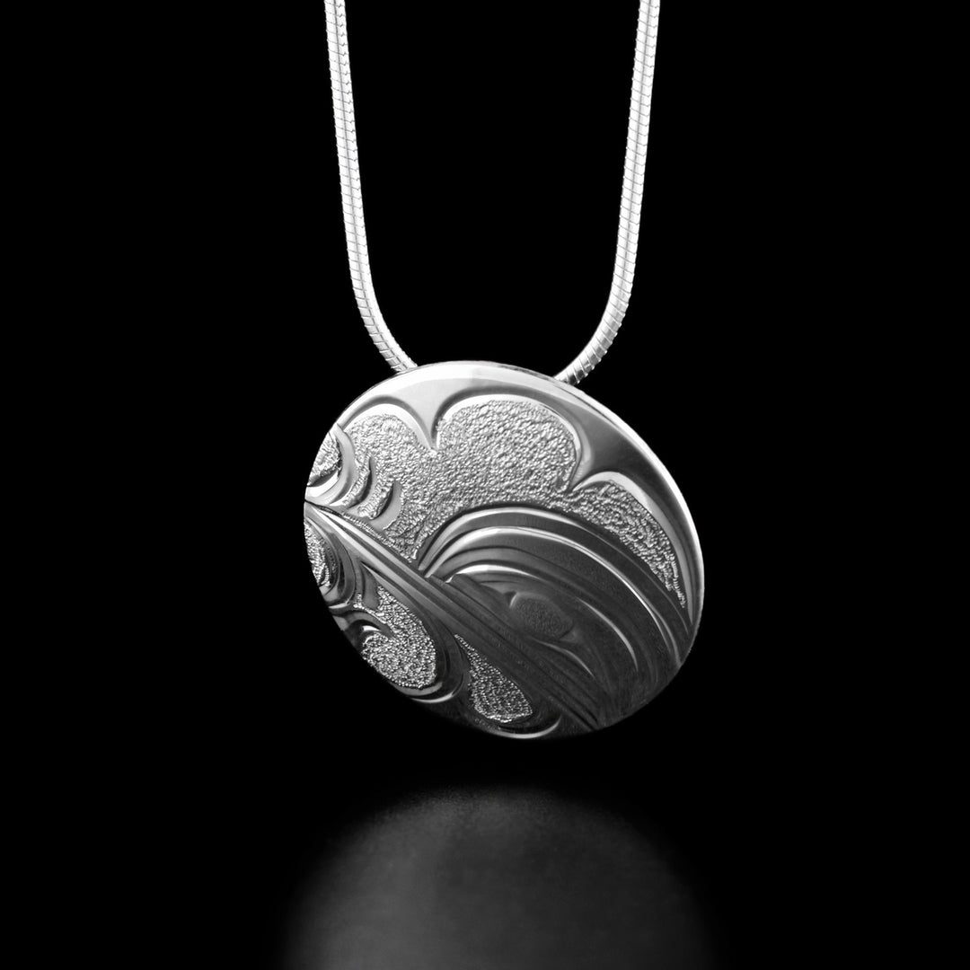 This hummingbird necklace has the profile of a hummingbird's head on the right drinking from a flower to its left.