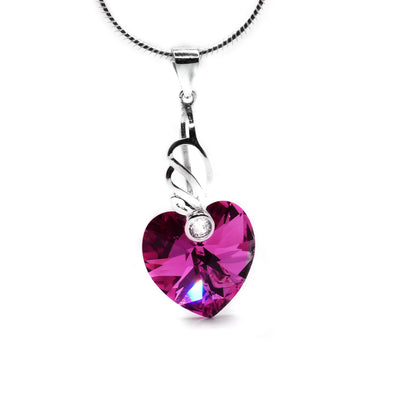 Rose Comet Swarovski Crystal Heart Pendant by Debra Nelson. The pink Swarovski crystal has been cut into a heart shape. The artist has handcrafted an intricate bail and has attached it to the top of the heart-shaped crystal. She has then set a cubic zirconia at the bottom of the bail.