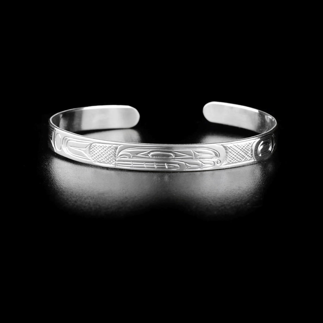 Orca cuff bracelet hand-carved by Kwakwaka'wakw artist Don Lancaster. Made of sterling silver. Bracelet is 6.20" long with 0.70" gap and has width of 0.25".