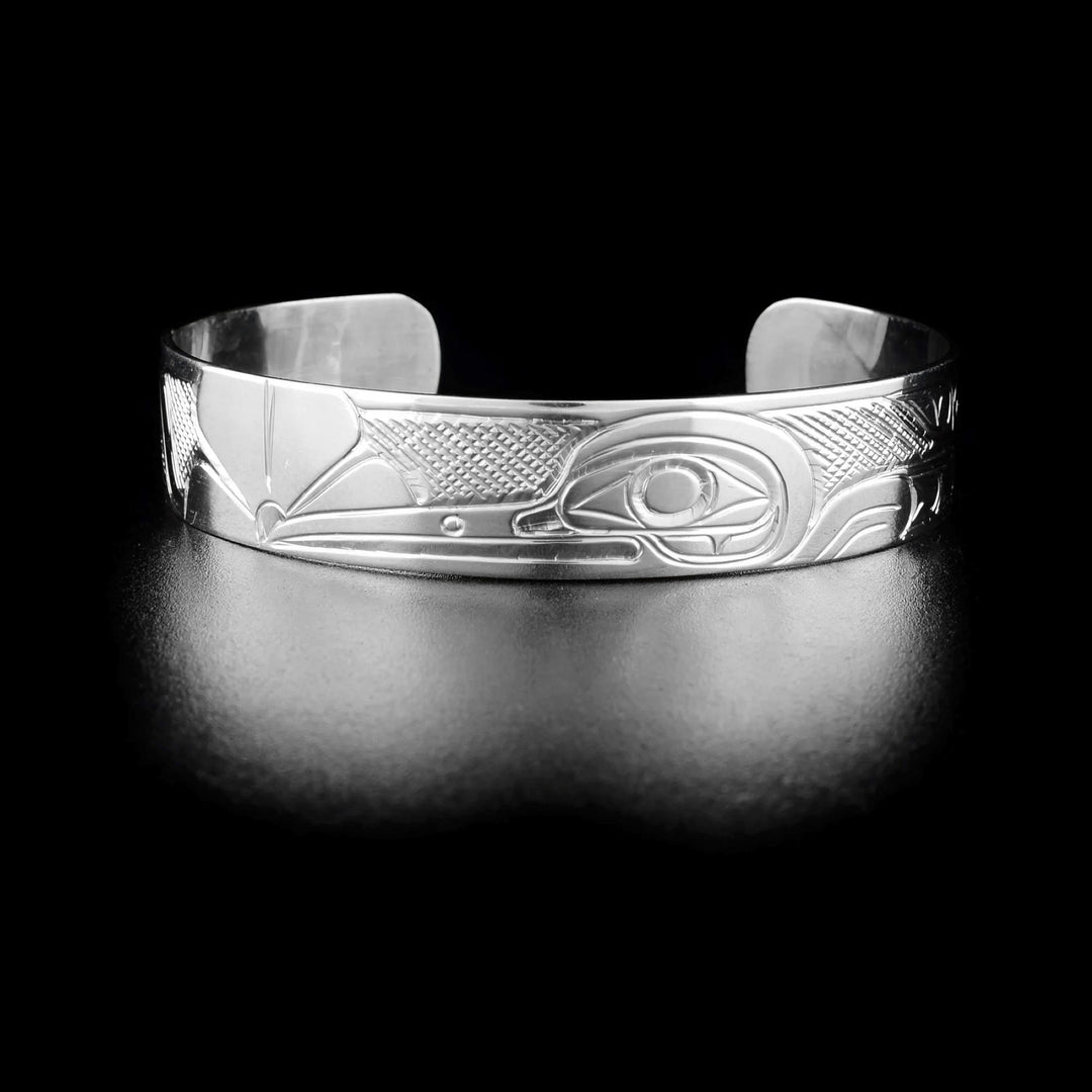 This Hummingbird bracelet cuff is made form sterling silver and has a single band with a gap in the back. There is a depiction of the Hummingbird and designs that have been beautifully carved into the surface of the band.