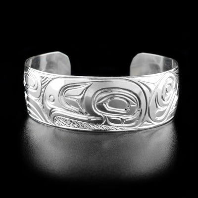 Sterling Silver 3/4" Eagle Bracelet by Paddy Seaweed. The design depicts the profile of an eagle's head facing the left. To the left of the head is the body and to the right are the eagle's wings. The background has been delicately hand carved by the artist to allow for the eagle's head to pop out.