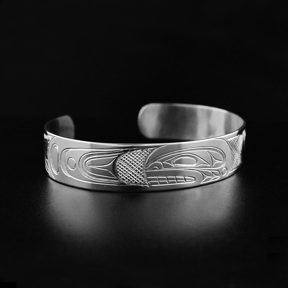 This Orca whale bracelet is made from sterling silver and is a cuff bracelet. There is a depiction of the Orca carved into the surface of the band.