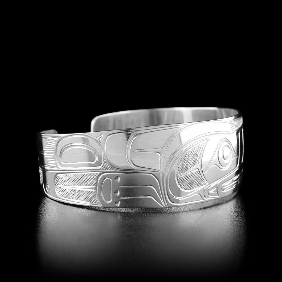 Left angle photo of the bracelet shows carved designs representing the body of the wolf.