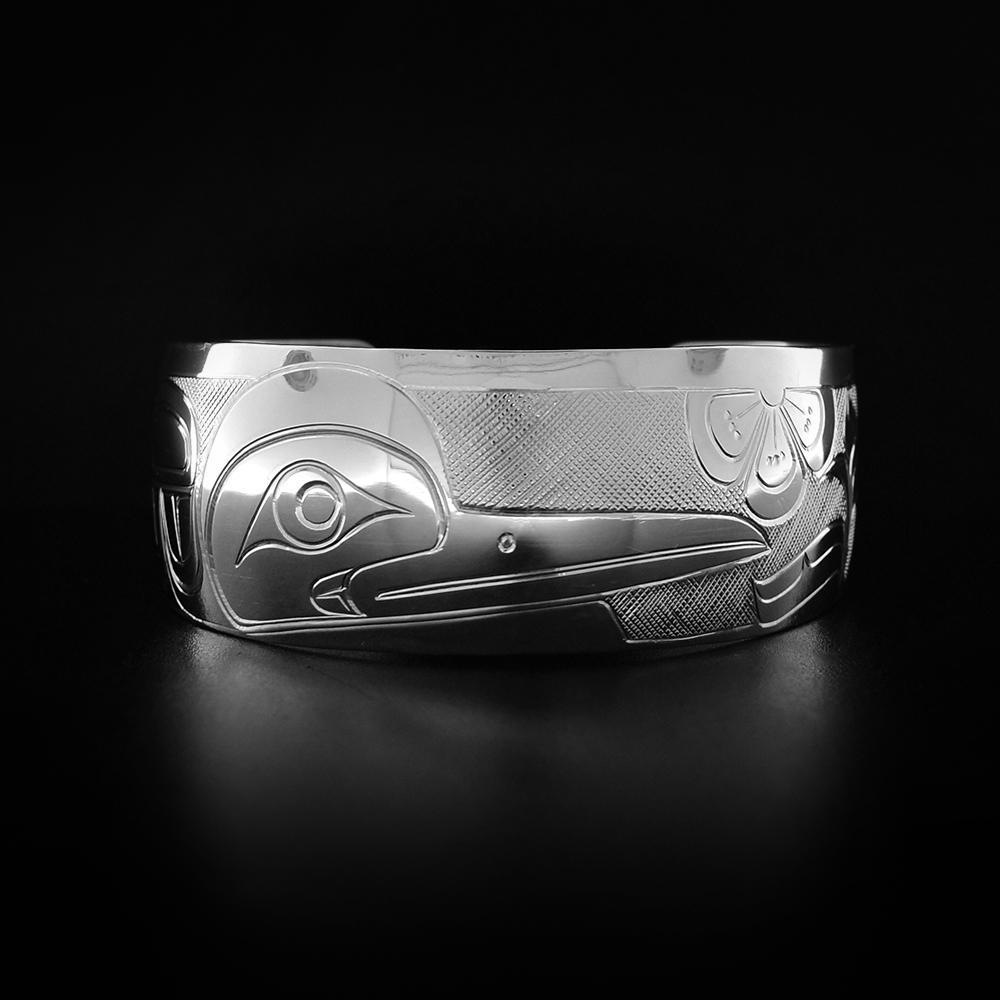 A sterling silver 1" Hummingbird bracelet with flowers. It depicts the face and wing of the Hummingbird.