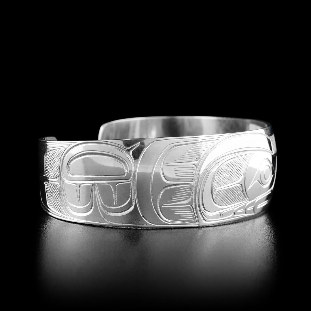 Left angle photo of the bracelet shows carved designs representing the wing of the raven.