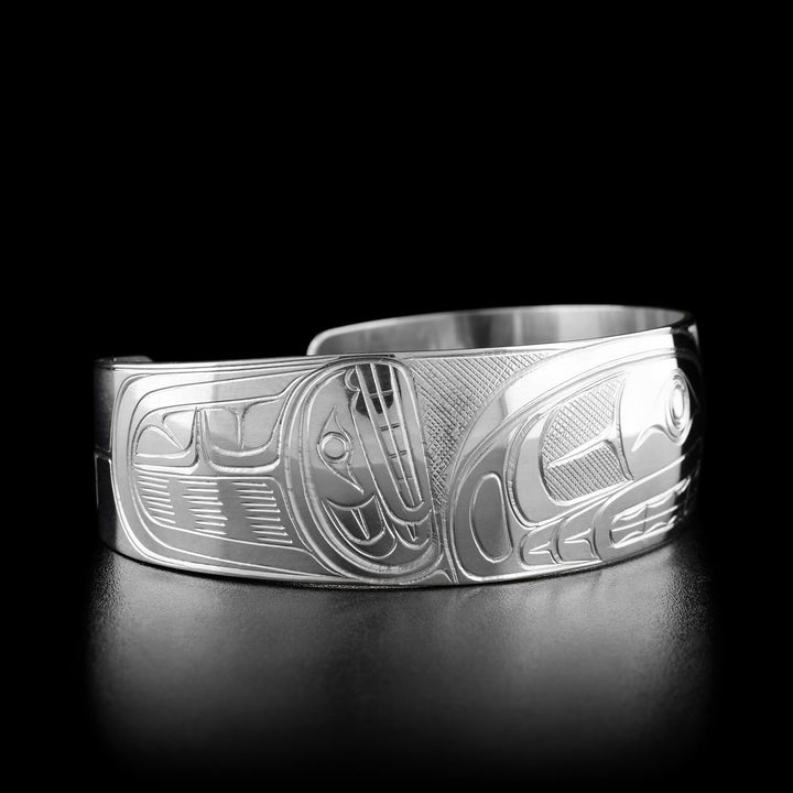 Left angle photo of the bracelet shows the head of a second orca facing upward and carved designs beside it.