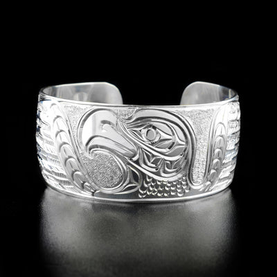 Sterling Silver Eagle with Spread Wings Bracelet by Paddy Seaweed. The design depicts the profile of an eagle's head and neck facing the left. To the left and right are the eagle's wings spread out as if mid flight. The artist has carefully hand carved the background to allow for the eagle to pop out.