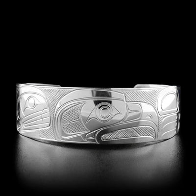 This silver bracelet has the profile of an eagle's head facing the right in the center with an open beak.