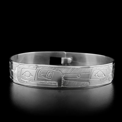 This clasp bracelet has the the head of a thunderbird and the head of a hummingbird facing towards each other in the center.