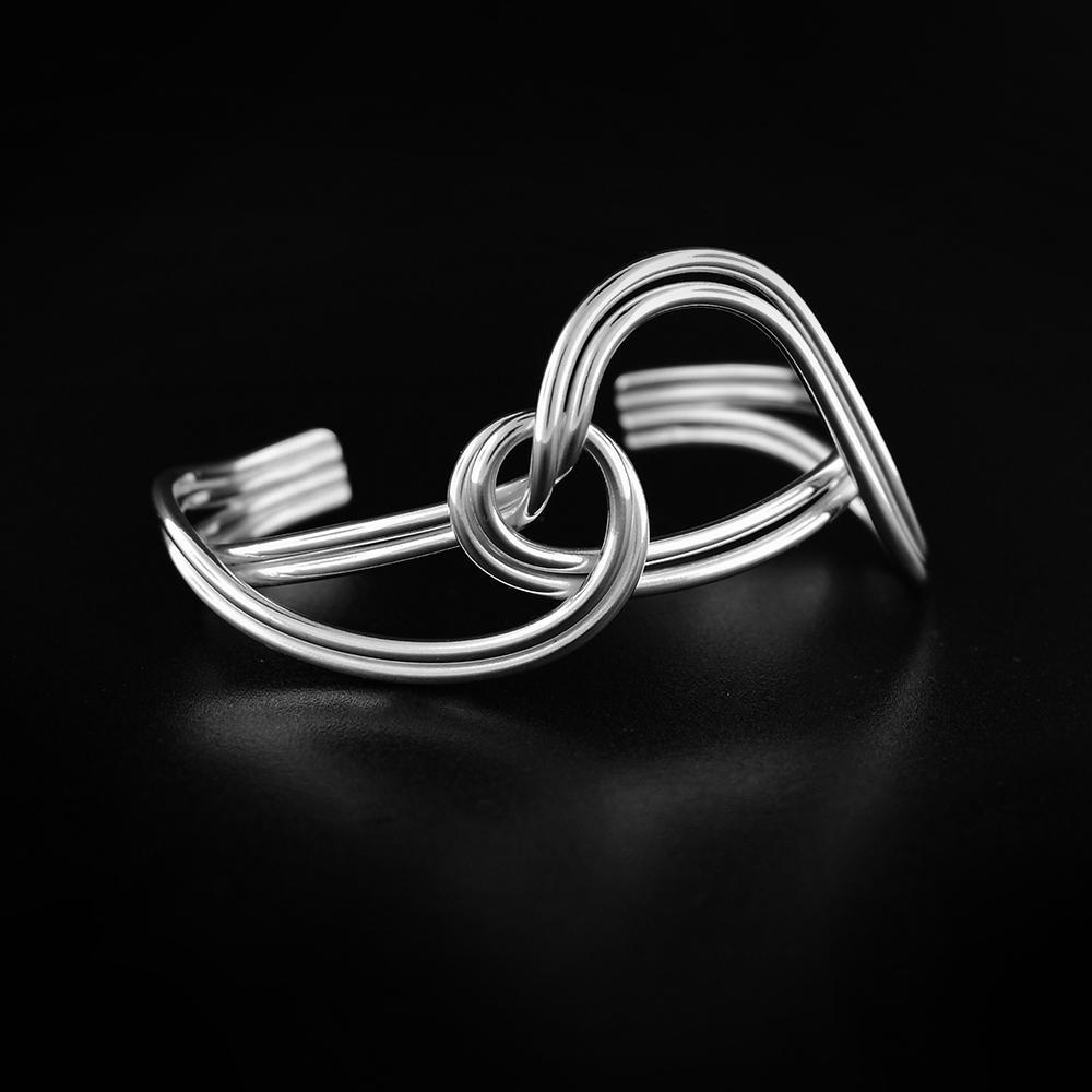This sterling silver cuff bracelet is made up of double wires that wrap and twist around each other. The design represents the love and connection we share with others.