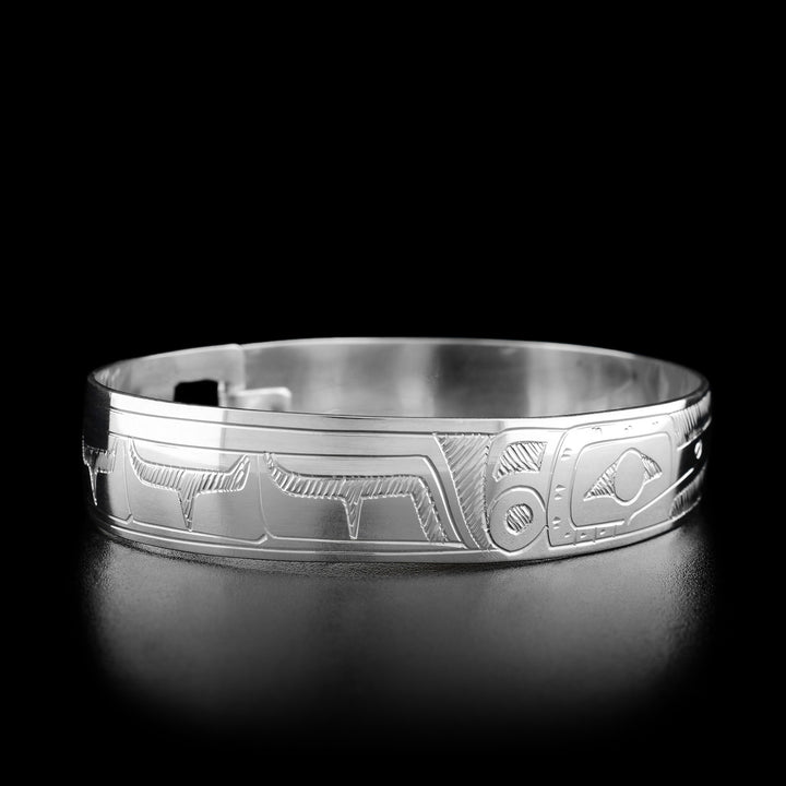 Left angle photo of the bracelet shows carved designs representing the spread wing of the hummingbird. Both sides of the bracelet are identical.