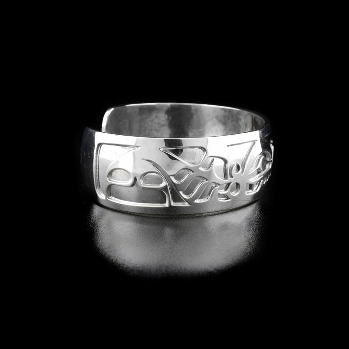 Left angle photo of the bracelet shows carved designs representing the first orca's body, fins, and tail.