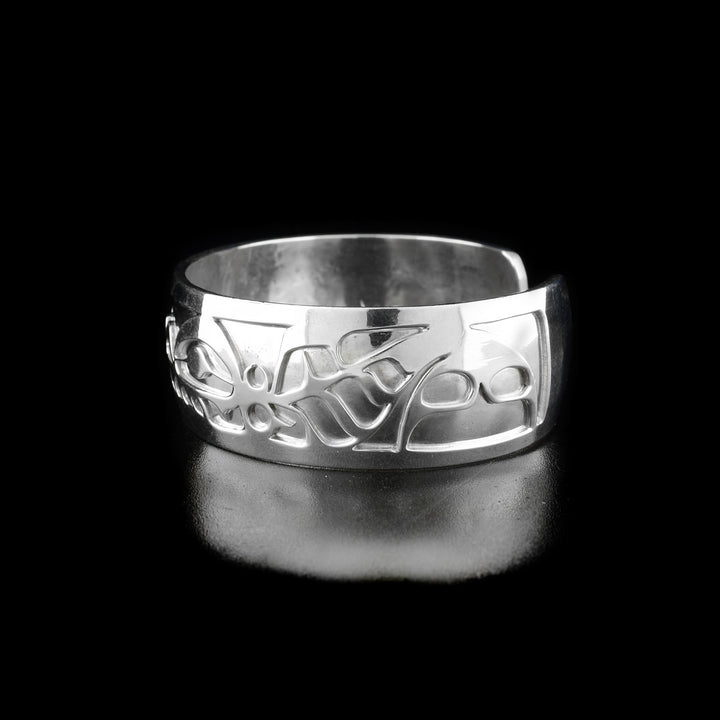 Right angle photo of the bracelet shows carved designs representing the second orca's body, fins, and tails.