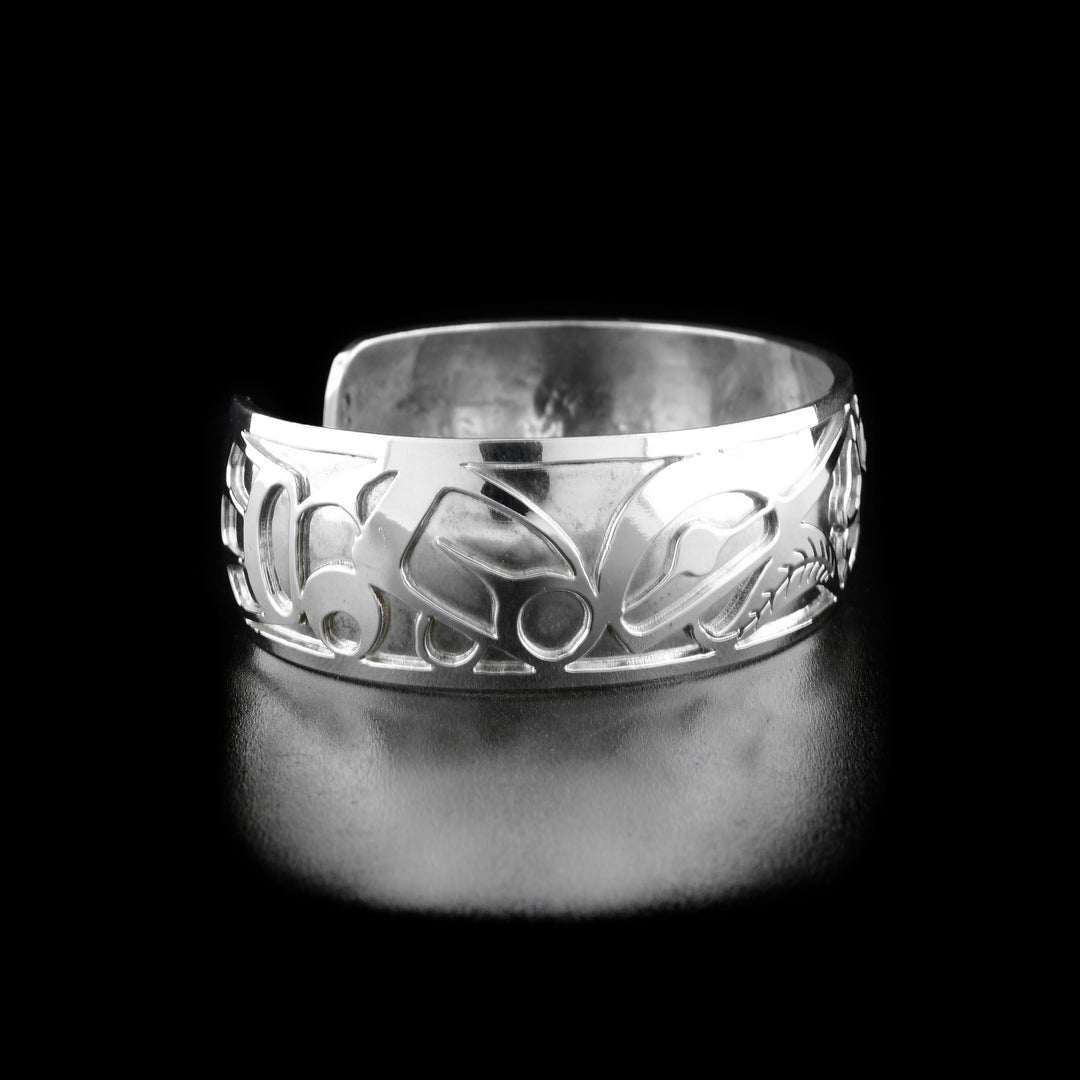 Left angle photo of the bracelet shows carved designs representing the body and wing of the first hummingbird.