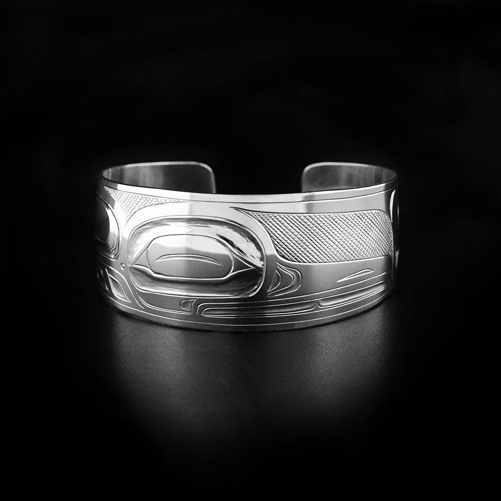 This wide cuff bracelet is made from sterling silver and has a gorgeous depiction of the Hummingbird carved into the surface of the band.