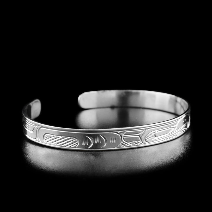 Left angle photo of eagle bracelet shows carved designs representing the eagle's body.