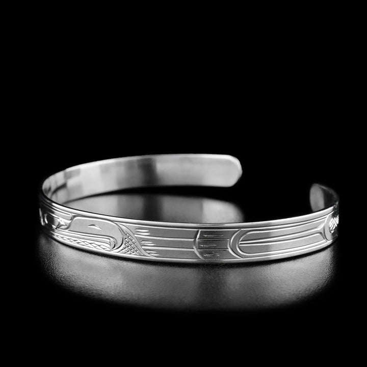 Right angle photo of eagle bracelet shows carved designs representing the eagle's feathers and wings.